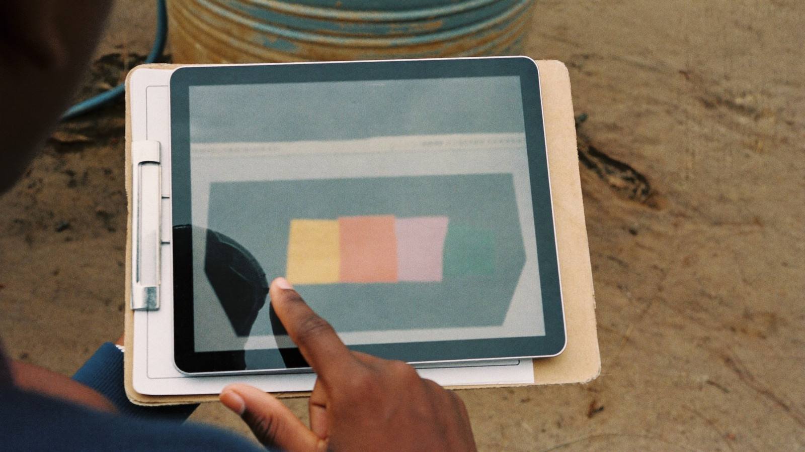 Field officer reviewing data on a tablet at a project site
