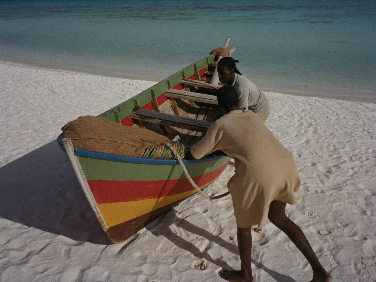 Fishermen pulling a wooden boat onto a Somali beach