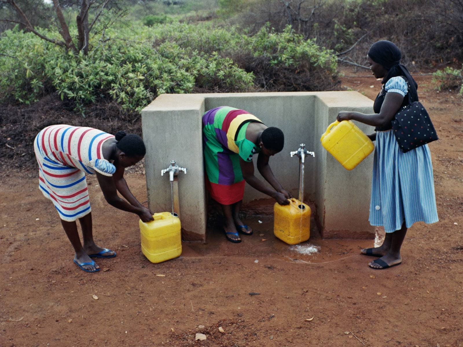 Women filling jerrycans at a new tap stand